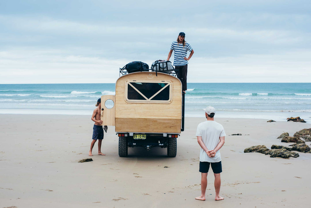 Jay Nelson with camper parked on beach checking the waves