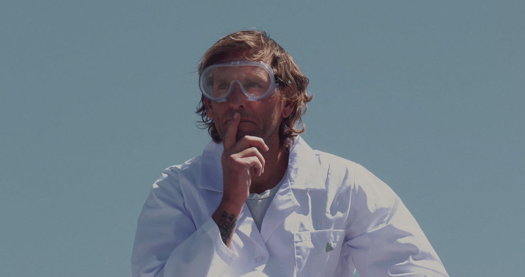 Person in scientist outfit and goggles sushing the camera